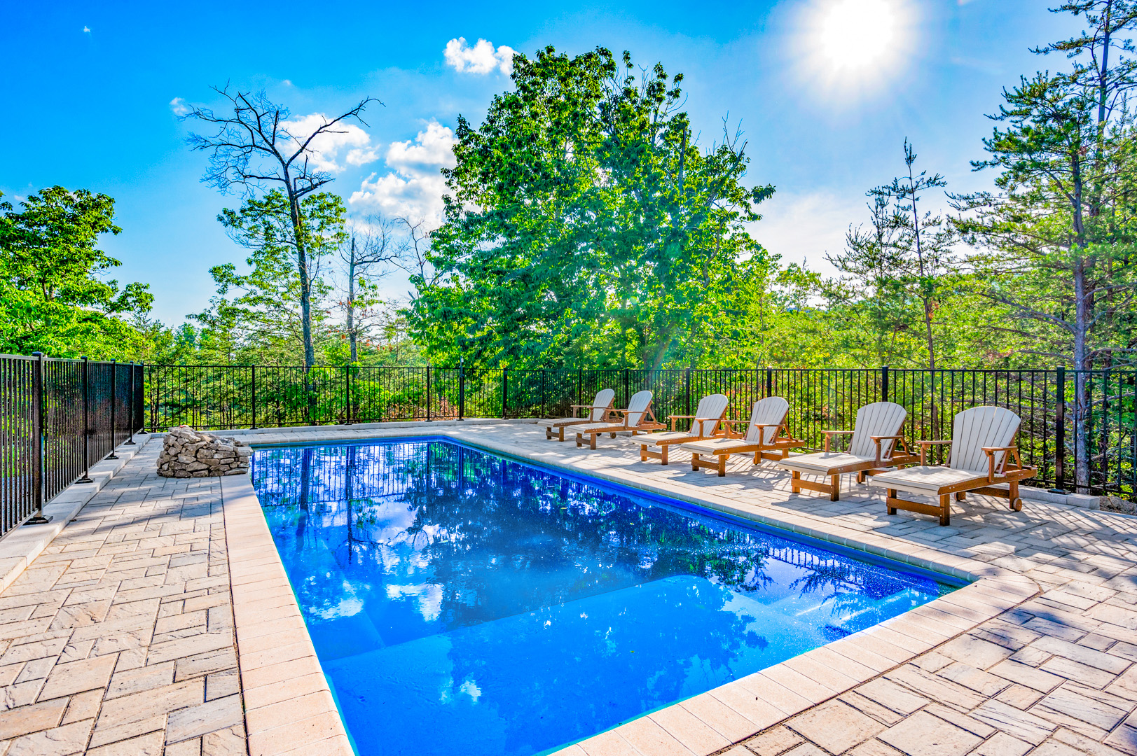 Sunlit private outdoor pool and poolside lounge chairs